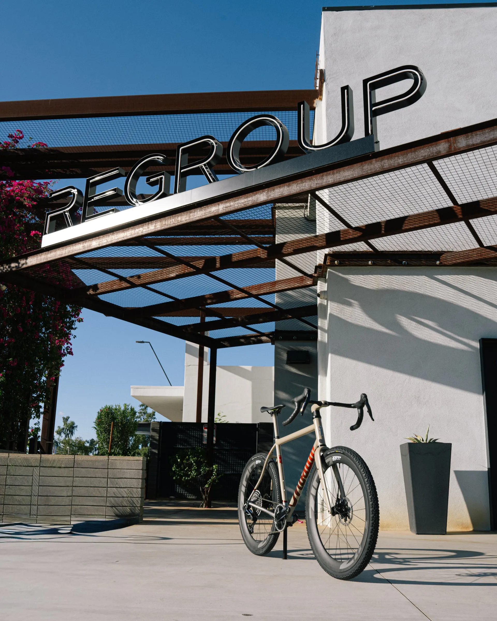 A gravel bike beneath the Regroup sign and steel canopy.